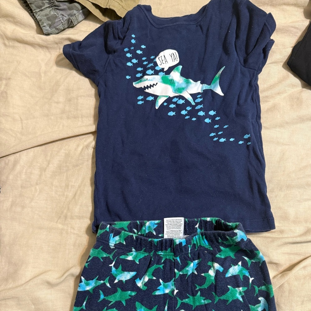 Boys shark Jammie’s size 5T fits like 4T. Small stain front of shirt in pics.